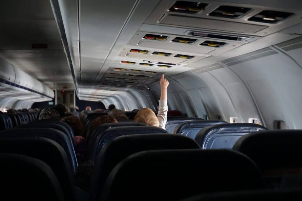Flying with children, baby on plane reaching to ceiling