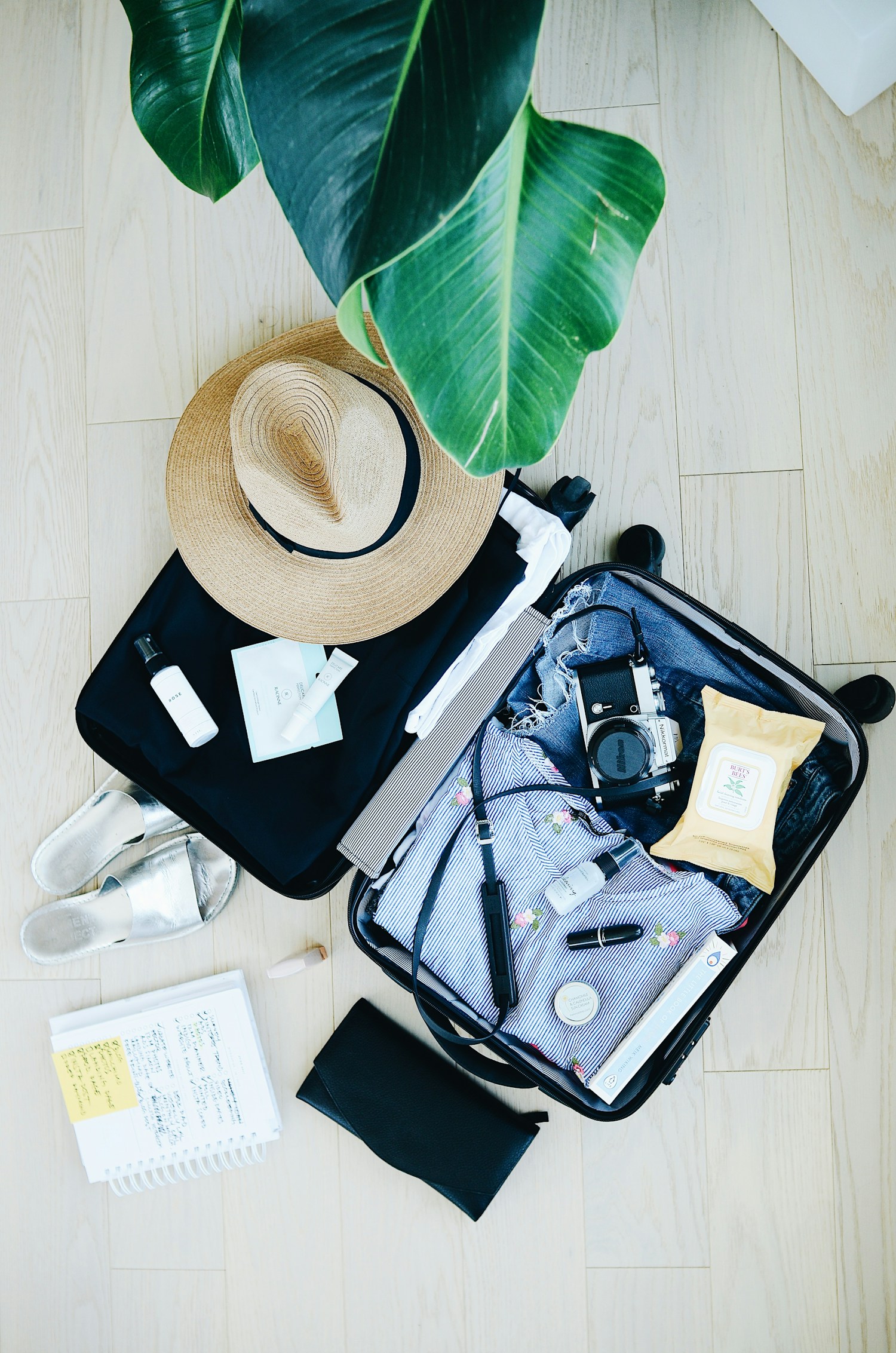 Open suitcase and travel essentials arranged on a floor